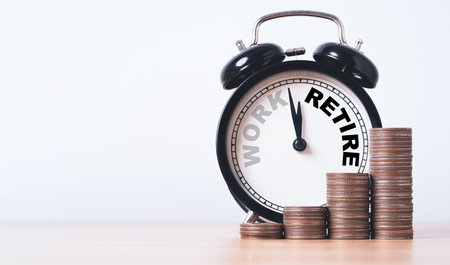 Work and retire inside alarm clock with coins stacking for wealth financial planning ,money saving and life insurance of retirement concept.の写真素材