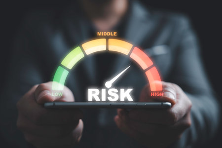 Businessman holding smartphone with  risk level indicator rating since low to high for Risk management and assessment concept.の写真素材