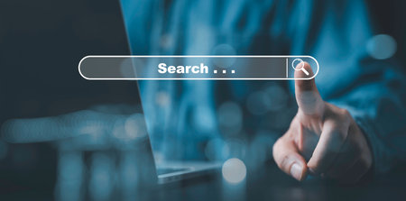 Businessman using computer laptop with search bar icon for browsing information network and SEO or search engine optimization concept.の写真素材