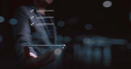 Businessman holding smartphone with correct sign mark for checklist and document approve of quality...