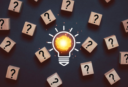 Glowing light bulb from yellow scrap paper among question mark for focus and concentrate of creative thinking idea and problem solving concept.の写真素材