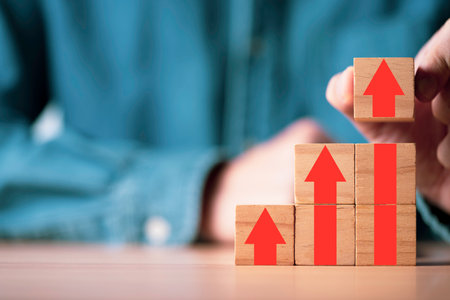 Businessman stacking red arrow on the top of wooden block for business growth and achievement success concept.の写真素材