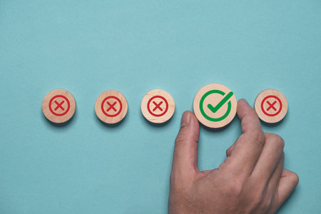 Hand holding green correct sign mark among Red Cross mark for business project approval and document approve concept.の写真素材