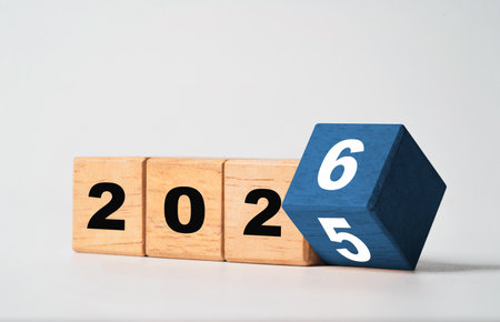 Flipping of 2025 to 2026 on wooden block cube for preparation new year change and start new business target strategy concept.の写真素材
