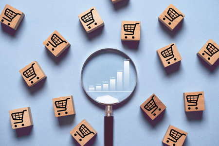 Increasing of graph chart inside of magnifier glass among shopping trolley cart for focus in business sale volume growth concept.の写真素材