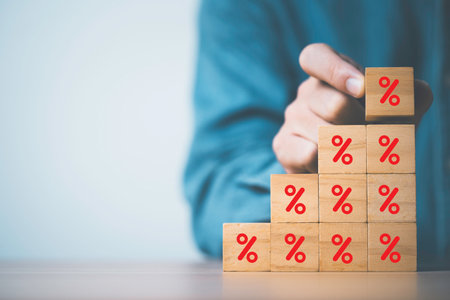 Businessman stacking increasing percentage of wooden block cube for  financial interest profit and dividend from investment and debt concept.の写真素材