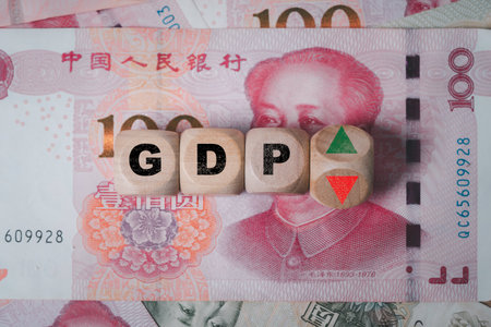 Top view of Flipping of wooden block cube to change up and down arrow on Yuan banknote for China GDP economic or Gross Domestic Product increasing and decreasing concept.の写真素材