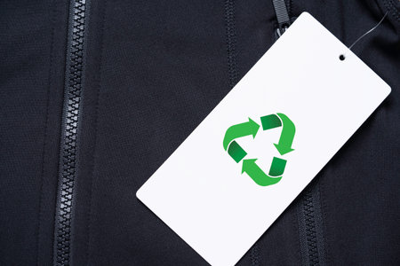 Green recycle on white paper sale tag of black shirt for reuse reduce and recycle for sustainability business and environment concept.の写真素材