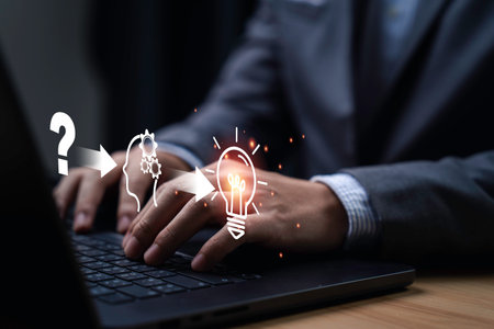 Businessman using laptop with icon from questioning to understanding and finally achieving an idea. It symbolizes the process of thought and innovation, highlighting creativity and problem-solving.の写真素材