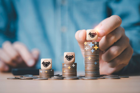 Businessman stacking hand shaking  on the top of increasing coins stacking for partnership  and collaboration can make more benefit and business profit investment concept.の写真素材