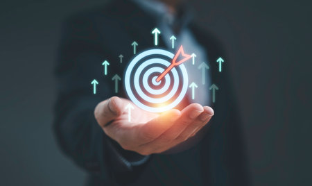 Businessman holding digital target with arrow hitting center, symbolizing business success strategy leadership vision and achieving goals for growth and marketing.の写真素材