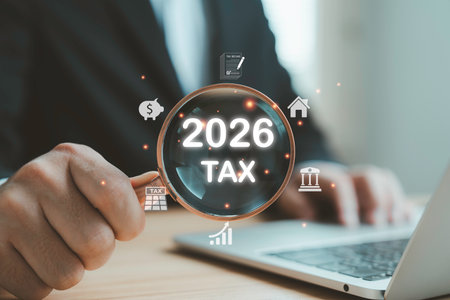 Businessman using magnifying glass to highlight 2026 tax planning, finance strategy and accounting...