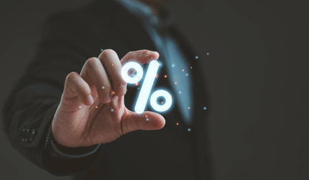 Businessman holding glowing percent sign symbol in hand representing finance interest rate discount loan investment growth marketing sales and digital business strategy concept.の写真素材