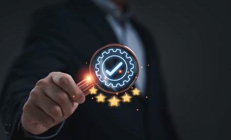 Businessman hand holding magnifying glass with glowing check mark and five stars symbolizing quality assurance customer satisfaction service excellence and business success on dark backgroundの写真素材