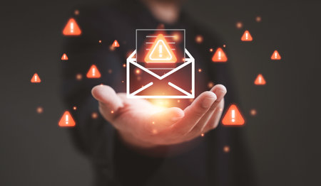 Spam concept showing a businessman holding a glowing envelope with warning icons representing junk mail phishing scam alert email risk data protection and cybersecurity awareness in digital communicationの写真素材