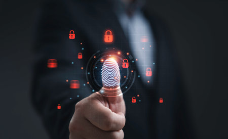 Businessman touching digital fingerprint scanning symbol representing cybersecurity data protection identity verification and secure access technology for modern business network safety.の写真素材