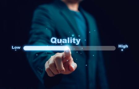 Businessman pointing on virtual bar with word quality showing improvement standard performance excellence growth success development and professional concept for high quality level upの写真素材