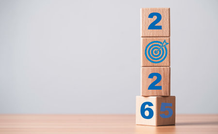 Wooden blocks arranged in a vertical stack flipping from 2025 to 2026 with a target icon symbolizing future goals business planning success vision and strategic development conceptの写真素材