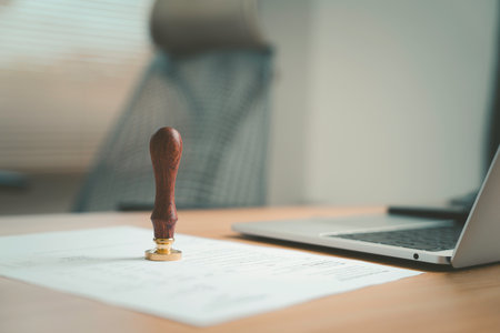 a wooden seal stamp placed on a document symbolizing authorization validation accuracy and official confirmation in professional business paperwork as an approval stamp conceptの写真素材