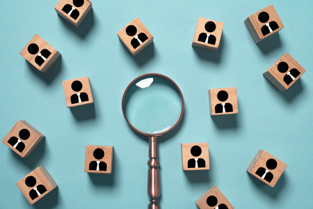 Recruitment concept with magnifying glass searching among candidate icons represents talent...