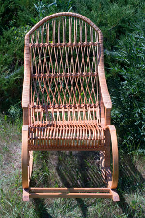 rocking chair on a green lawn, against the background of juniperの写真素材
