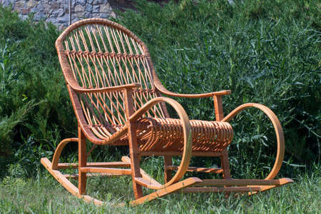 rocking chair on a green lawn, against the background of juniperの写真素材