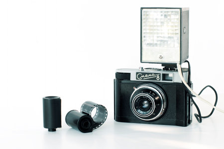 Dnipropetrovsk, Ukraine - June 11, 2022: Antique film photo camera Smena 8, with flash, photo reel, on a white isolated backgroundのeditorial素材
