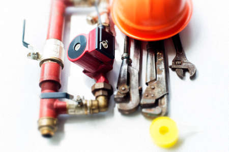 circulation pump of the heating system is built into the bypass, the gas key and the work helmet, on an isolated white backgroundの写真素材