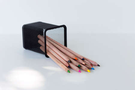 multi-colored pencils fell out of a fallen glass, on a white backgroundの写真素材