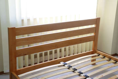 frame of a simple lacquered bed made of wood with slats without mattressの写真素材