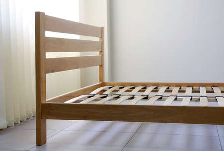 frame of a simple lacquered bed made of wood with slats without mattressの写真素材