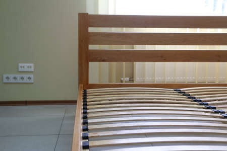 frame of a simple lacquered bed made of wood with slats without mattressの写真素材