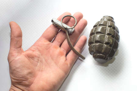 broken army training grenade on the palm, isolated backgroundの写真素材