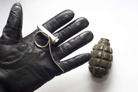 broken army practice grenade on gloved palm, isolated backgroundの写真素材