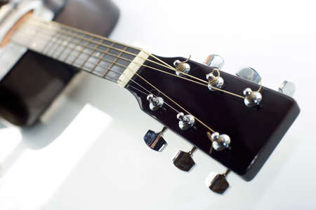 fretboard with strings of an acoustic guitar, on a white background, selective focus