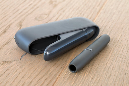 tobacco heating device on a wooden surface, an alternative to traditional cigarettesの写真素材