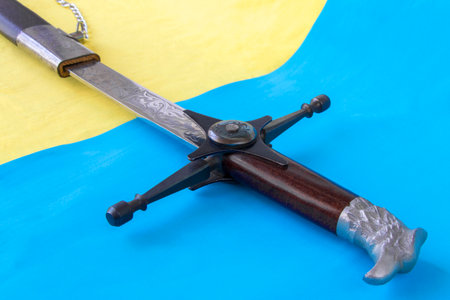 Cossack saber in a scabbard, close-up against the background of the flag of Ukraine