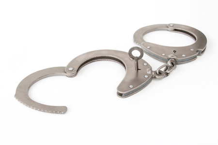 the inserted key opens the handcuffs, on a white isolated backgroundの写真素材