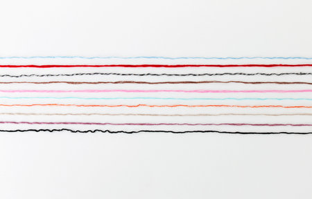 multi-colored threads of yarn laid out on a white background, close-upの写真素材