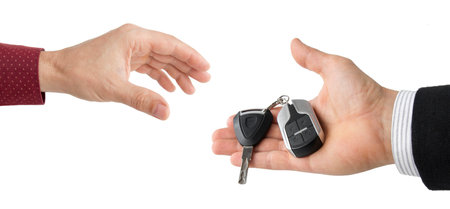 hand of businessman passing car keys to hand isolated on whiteの写真素材