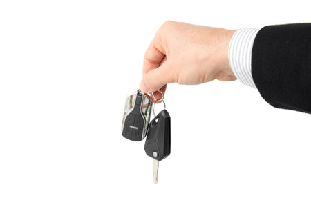 Businessman holding car key isolated on whiteの写真素材