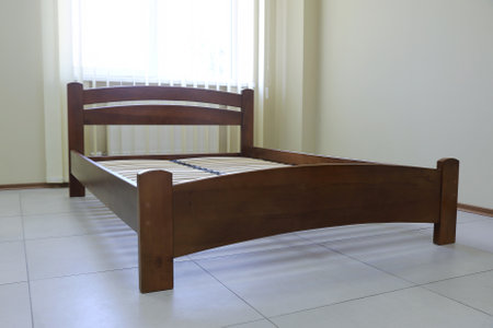 lacquered arched wooden bed with slats without mattressの写真素材
