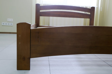 lacquered arched wooden bed with slats without mattressの写真素材