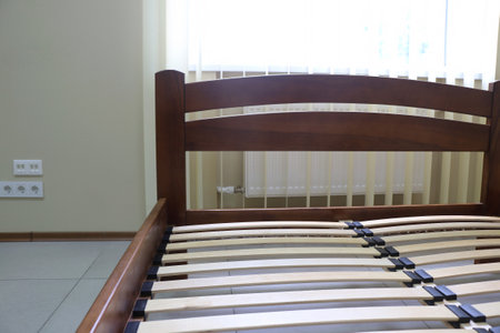 lacquered arched wooden bed with slats without mattressの写真素材