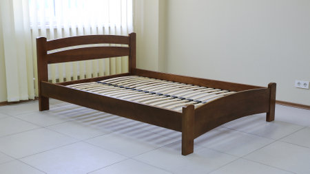 lacquered arched wooden bed with slats without mattressの写真素材