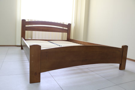 lacquered arched wooden bed with slats without mattressの写真素材