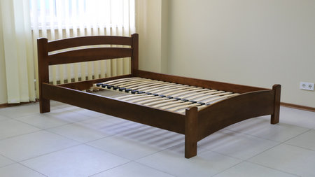 lacquered arched wooden bed with slats without mattressの写真素材