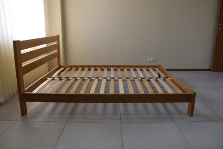frame of a simple lacquered bed made of wood with slatsの写真素材