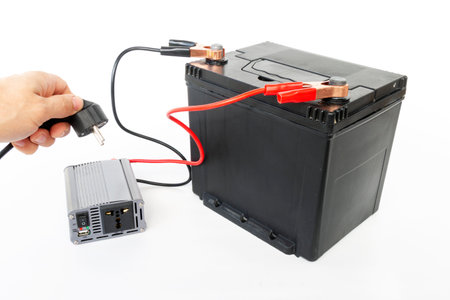 connecting a network wire to a power inverter, connected to a 12v battery, a DC to AC converter, on an isolated white backgroundの写真素材