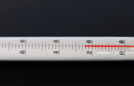close-up mercury thermometer, 25 degrees Celsius, on a isolated black backgroundの写真素材